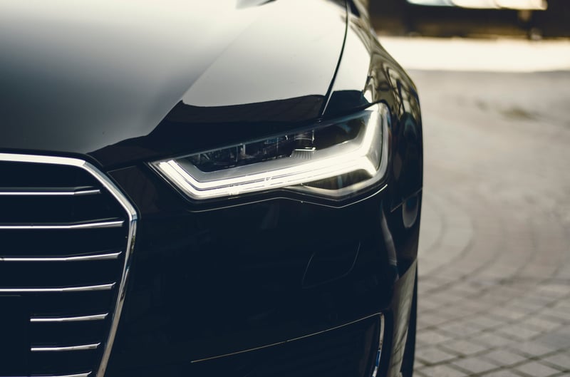 Head-on view of the front-right side of a car, depicting the grille and a headlight