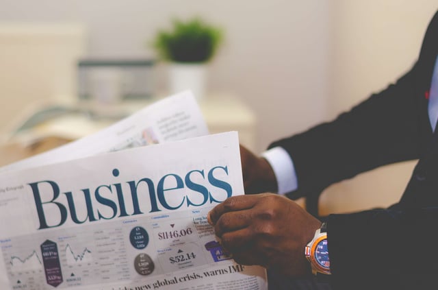 Man opening a business newspaper