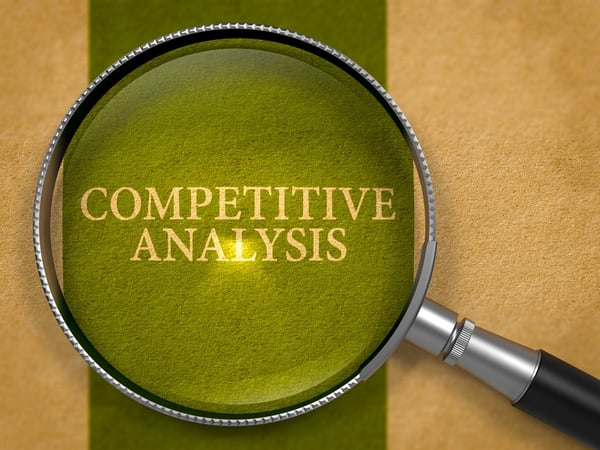 Magnifying glass over the words competitive analysis