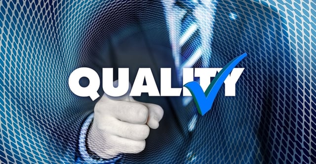 A man in a suit points with the word quality and a checkmark superimposed on the photo