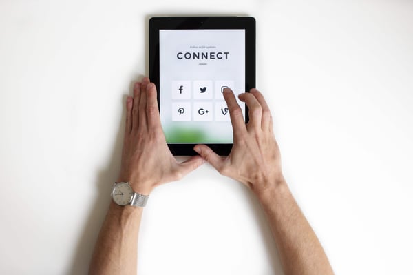 Man pressing a social media button on a tablet