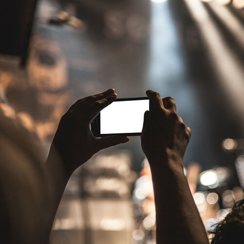 Person holding up a smartphone at a concert