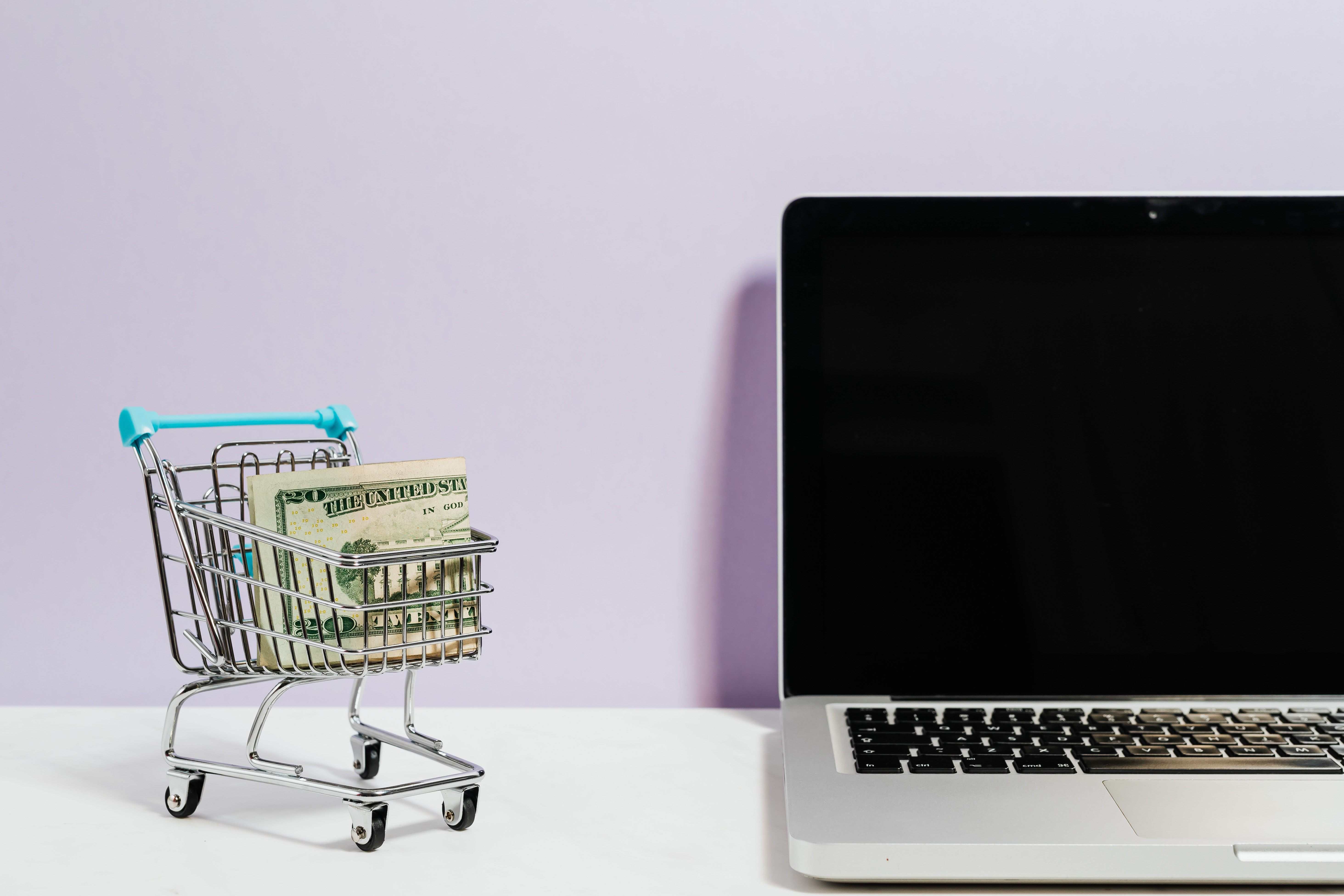 Shopping Cart With Cash Next To Laptop