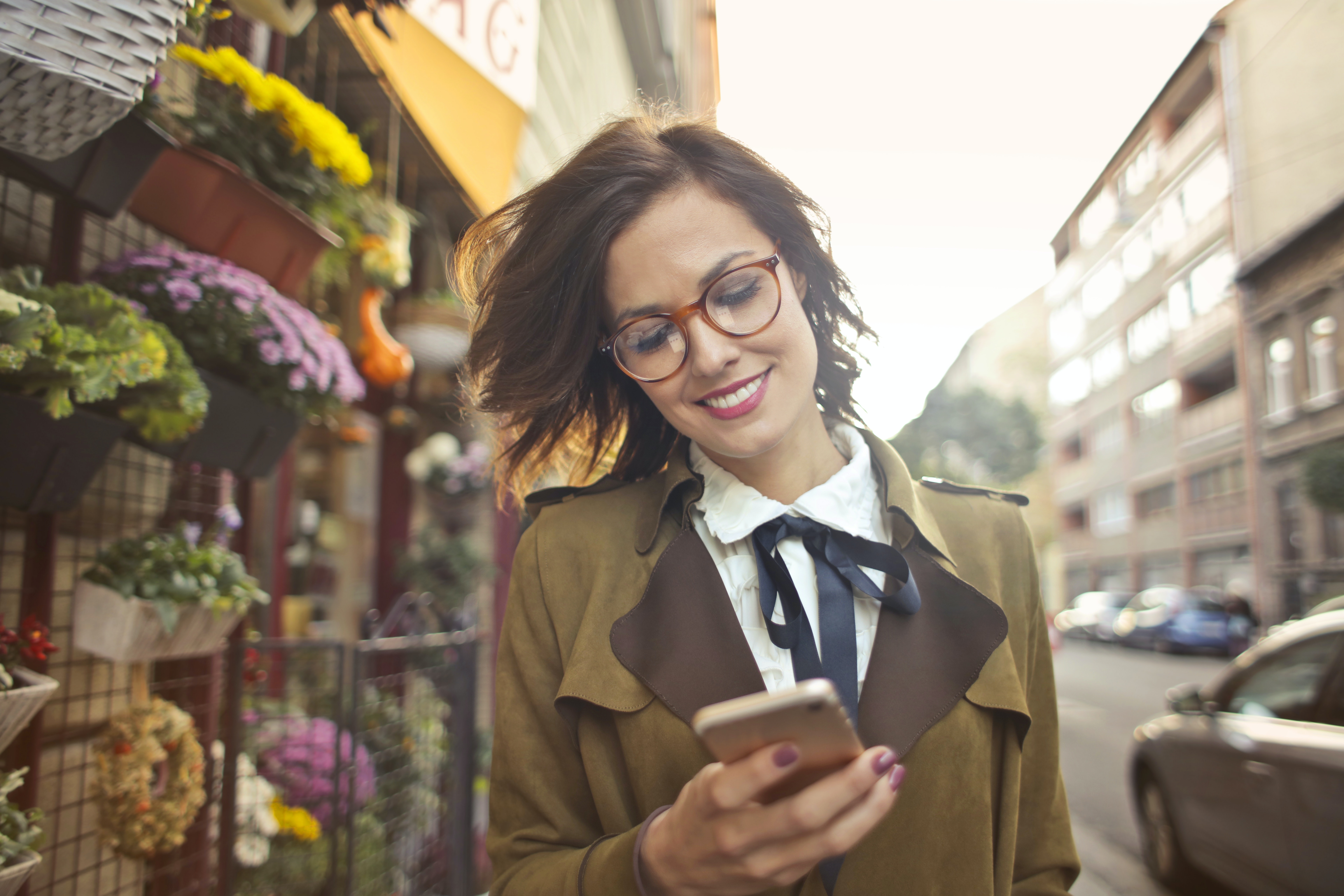 Online Shopper On Mobile Device Walking Down The Street Reading Market-Driven Media Content